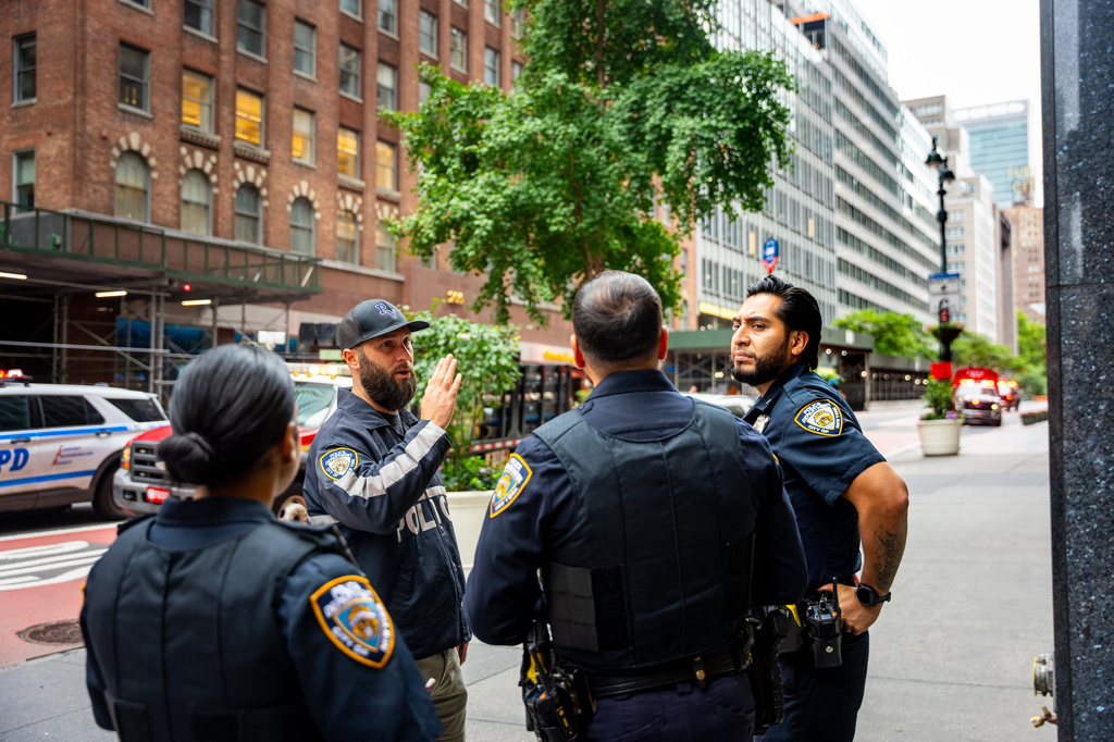 NYPD officers talk about nearby buildings that were evacuated, Tuesday, July 7, 2026, in New York. (AP Photo/Angelina Katsanis)