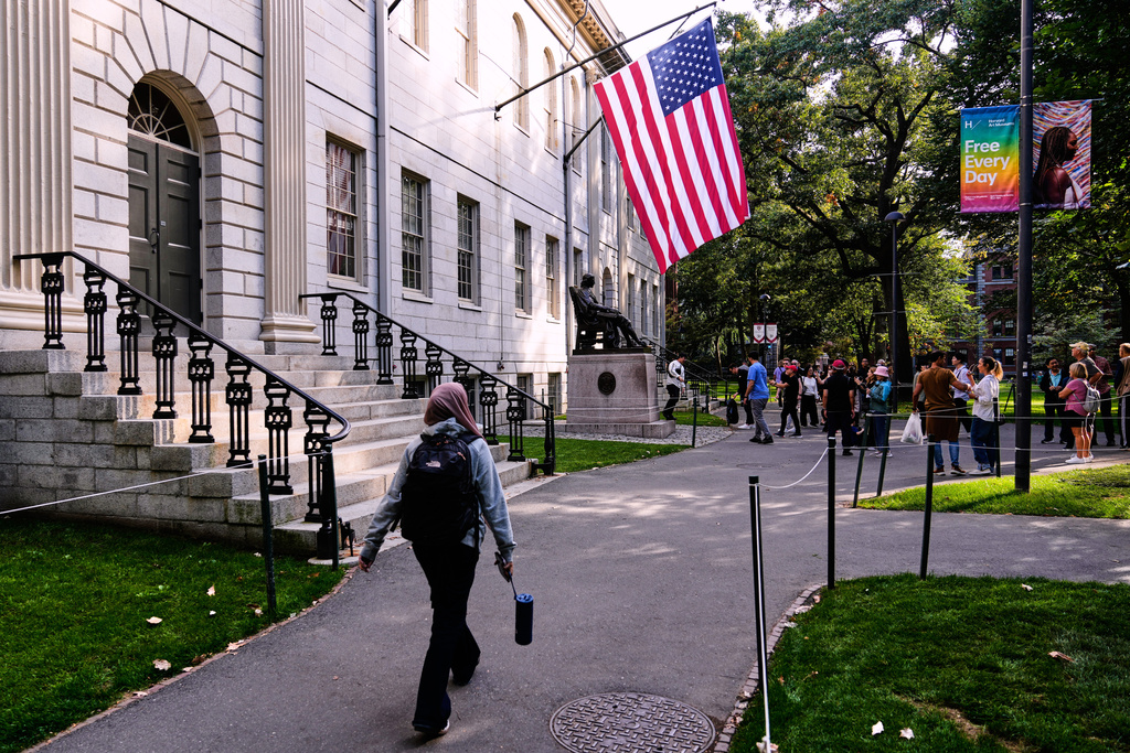 A woman walks through Harvard Yard at Harvard University, Tuesday, Sept. 30, 2025, in Cambridge, Mass. (AP Photo/Charles Krupa)