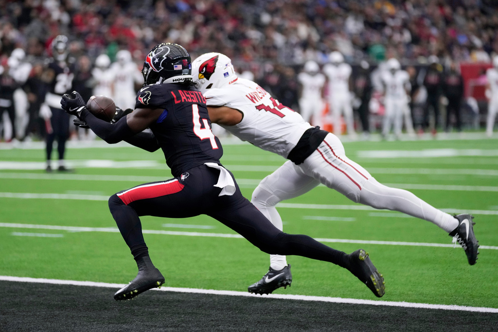 Houston Texans cornerback Kamari Lassiter (4) intercepts a pass against Arizona Cardinals wide receiver Michael Wilson during the second half of an NFL football game Sunday, Dec. 14, 2025, in Houston. (AP Photo/Eric Christian Smith)