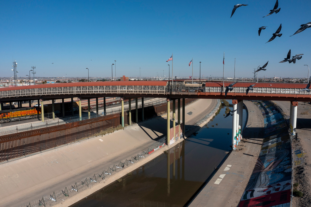 FILE - Pigeons fly over the Rio Grande river and the Paso del Norte bridge that connects Ciudad Juarez, Mexico, and El Paso, Texas, Jan. 19, 2025, in Ciudad Juarez, Mexico. (AP Photo/Andres Leighton, File)
