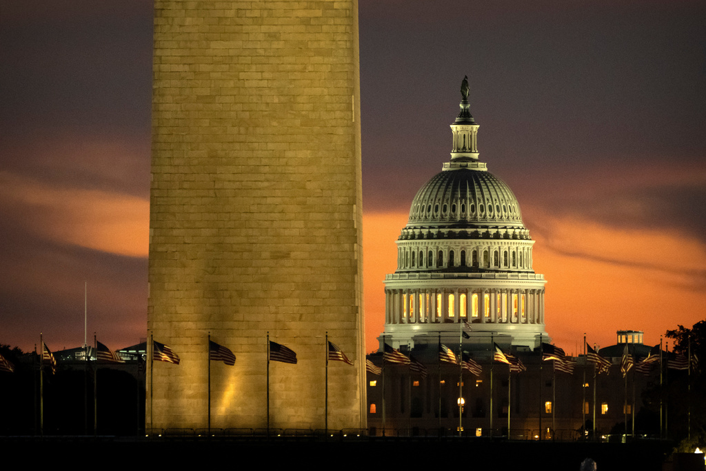 The base of the Washington Monument and the dome of the U.S. Capitol are seen at dawn on Wednesday, Oct. 1, 2025, in Washington. (AP Photo/Mark Schiefelbein)