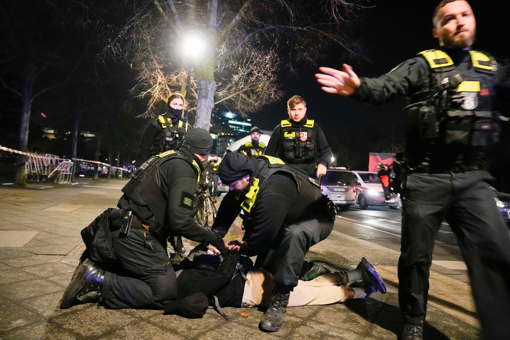 FILE -Police officers detain a man at the Holocaust memorial in Berlin, Germany, after another man was seriously injured, Feb. 21, 2025. (AP Photo/Ebrahim Noroozi, File)