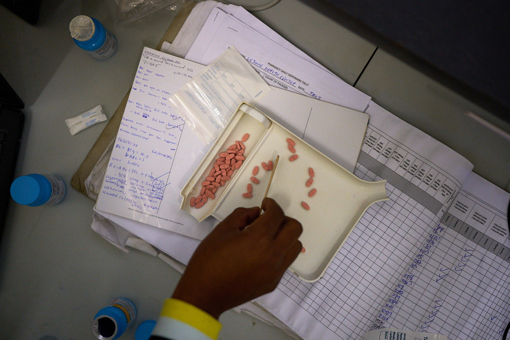 FILE - A pharmacist counts HIV medicine inside a clinic in Ha Lejone, Lesotho, July 16, 2025. (AP Photo/Bram Janssen, File)