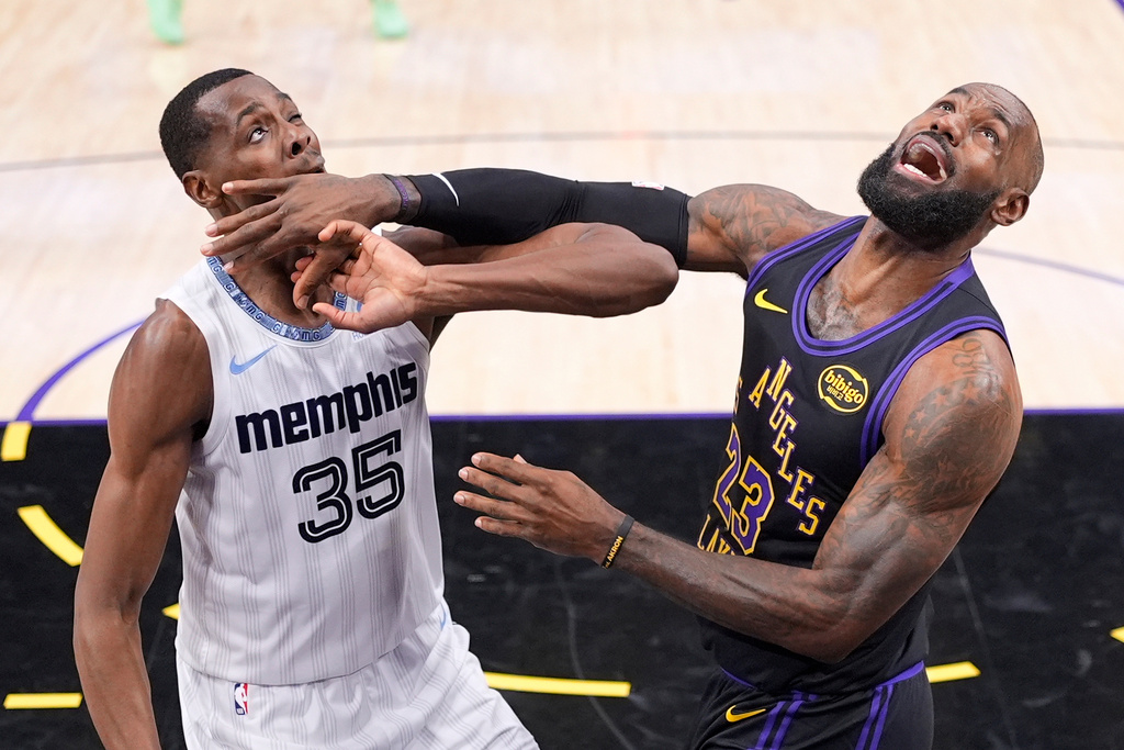 Memphis Grizzlies center Christian Koloko, left, is hit in the face by Los Angeles Lakers forward LeBron James as they wait for a rebound during the first half of an NBA basketball game Friday, Jan. 2, 2026, in Los Angeles. (AP Photo/Mark J. Terrill)