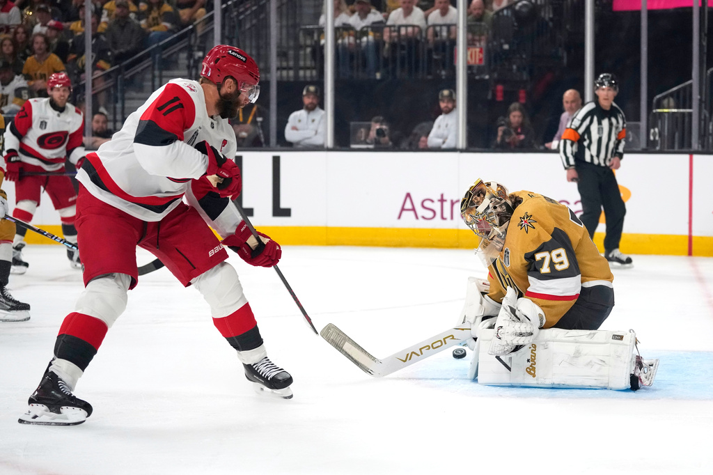 Carolina Hurricanes center Jordan Staal, left, tries to get a shot past Vegas Golden Knights goaltender Carter Hart during the first period in Game 3 of the NHL hockey Stanley Cup Final series Saturday, June 6, 2026, in Las Vegas. (AP Photo/John Locher)
