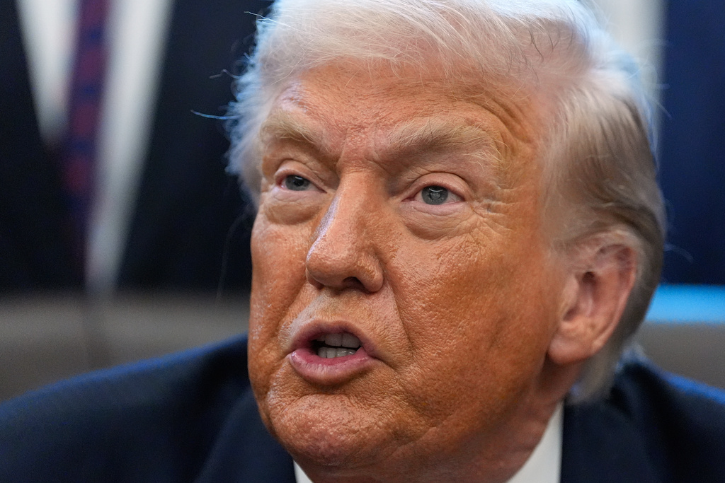 President Donald Trump answers questions after signing a bill that returns whole milk to school cafeterias across the country, in the Oval Office of the White House, Wednesday, Jan. 14, 2026, in Washington. (AP Photo/Alex Brandon)