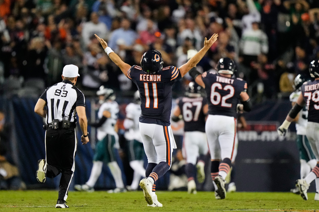 Chicago Bears quarterback Case Keenum (11) celebrates after throwing a touchdown pass to wide receiver Kalif Raymond as referee Shawn Hochuli (83) runs past during the second half of an NFL football game against the Philadelphia Eagles in Chicago, Monday, Sept. 28, 2026. (AP Photo/Nam Y. Huh)