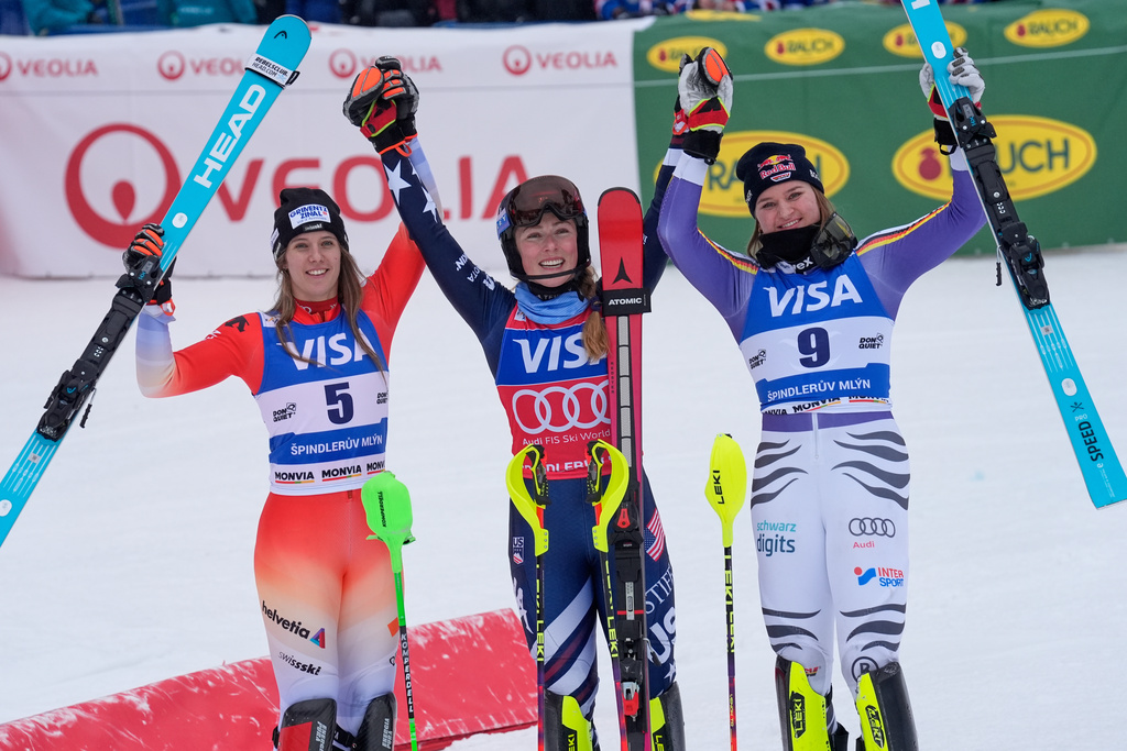 United States' Mikaela Shiffrin, center, winner of an alpine ski, women's World Cup slalom, poses with second placed Switzerland's Camille Rast, left, and third placed Germany's Emma Aicher, in Spindleruv Mlyn, Czech Republic, Sunday, Jan. 25, 2026. (AP Photo/Giovanni Auletta)