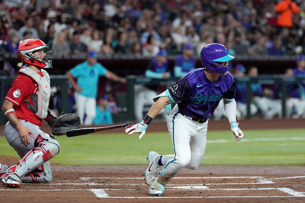Arizona Diamondbacks' Corbin Carroll, right, and Cincinnati Reds catcher Will Banfield, left, watch the flight of Carroll's double during the first inning of a baseball game, Sunday, Aug. 23, 2026, in Phoenix. (AP Photo/Ross D. Franklin)