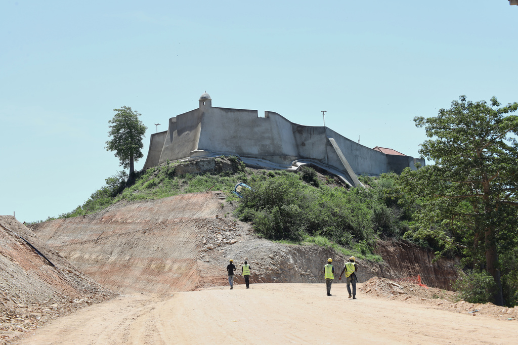 Workers walk by the 16th century fortress in Muxima, Angola, Saturday, April 11, 2026. (AP Photo)