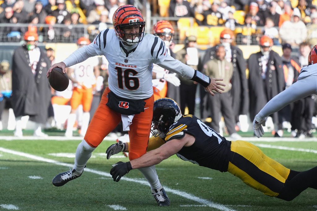 Cincinnati Bengals quarterback Joe Flacco (16) avoids a tackle by Pittsburgh Steelers linebacker T.J. Watt (90) during the first half of an NFL football game Sunday, Nov. 16, 2025, in Pittsburgh. (AP Photo/Gene J. Puskar)