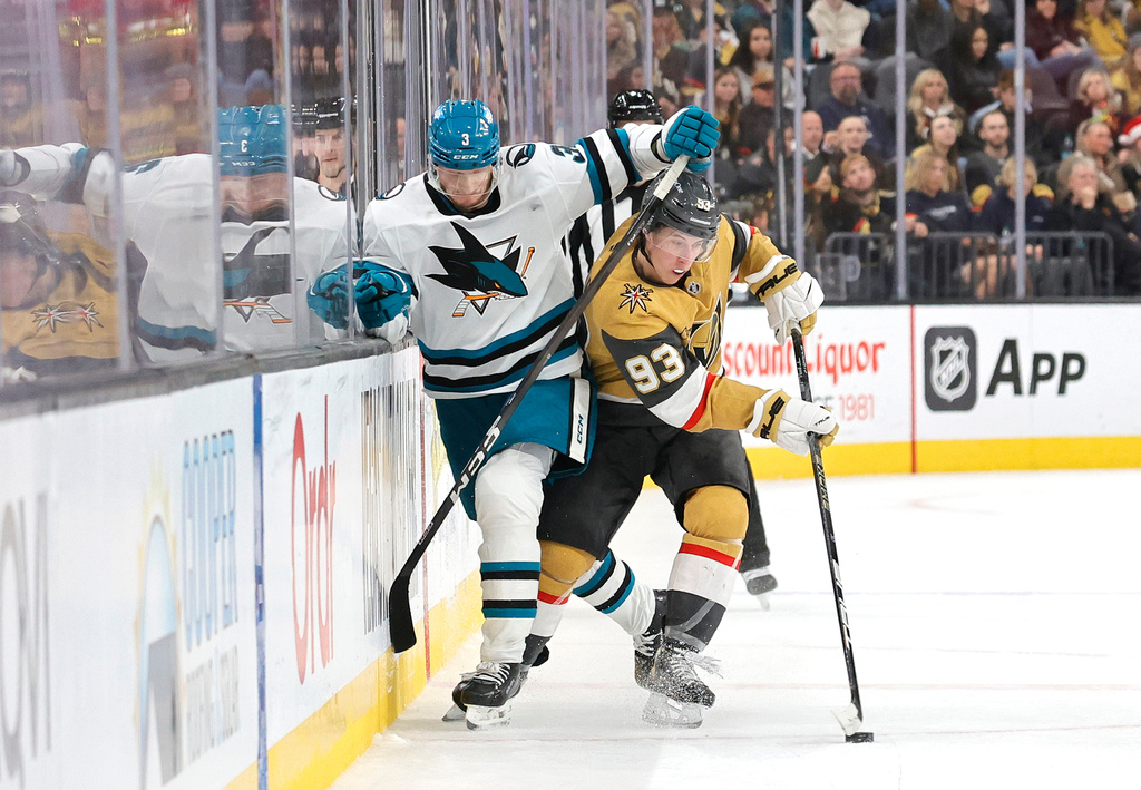 San Jose Sharks defenseman John Klingberg (3) and Vegas Golden Knights right wing Mitch Marner (93) fight for the puck during the second period of an NHL hockey game Tuesday, Dec. 23, 2025, in Las Vegas. (AP Photo/Steve Marcus)