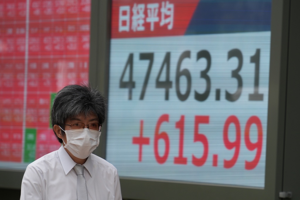 A person walks in front of an electronic stock board showing Japan's Nikkei index at a securities firm Wednesday, Oct. 15, 2025, in Tokyo. (AP Photo/Eugene Hoshiko)