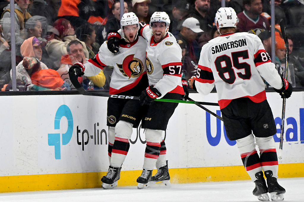 CORRECTS TO THIRD PERIOD - Ottawa Senators right wing Drake Batherson, left, is congratulated Senators' left wing David Perron and defenseman Jake Sanderson (85) after scoring the winning goal during the third period of an NHL hockey game against the Anaheim Ducks, Thursday, Nov. 20, 2025, in Anaheim, Calif. (AP Photo/Jayne Kamin-Oncea)