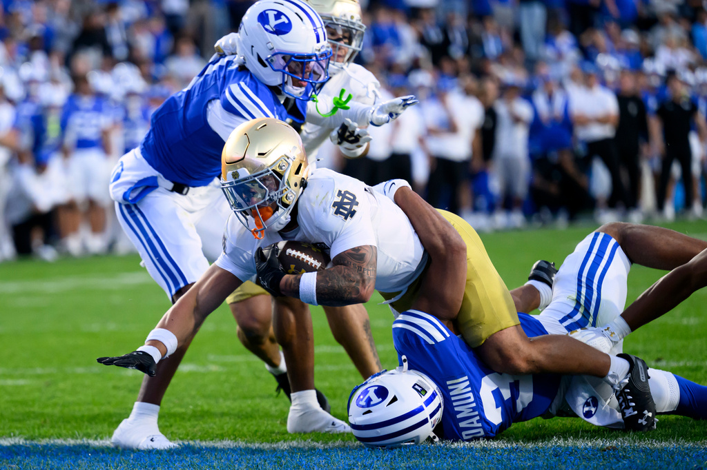 Notre Dame running back Nolan James Jr., front top, is tackled into the end zone by BYU safety Raider Damuni, bottom, right, during the first half of an NCAA college football game, Saturday, Oct. 17, 2026, in Provo, Utah. (AP Photo/Tyler Tate)