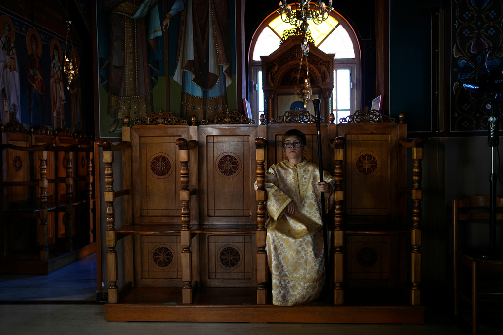 Pantelis, an altar server, sits at the Church of St. Fanourios in Athens, Tuesday, Aug. 25, 2026. (AP Photo/Thanassis Stavrakis)
