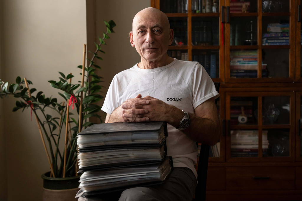 Lev Radin poses for a picture with his MetroCard collection, Dec. 10, 2025, in New York. (AP Photo/Yuki Iwamura)