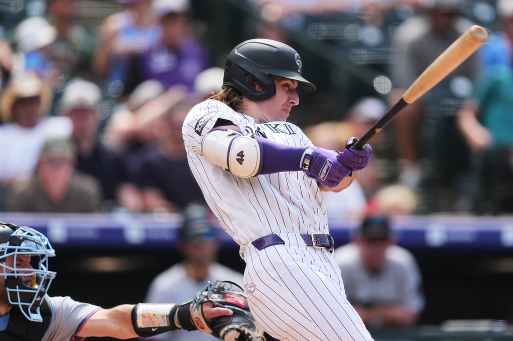 Colorado Rockies' Jake McCarthy hits a two-run single off Miami Marlins relief pitcher Calvin Faucher in the sixth inning of a baseball game Thursday, July 2, 2026, in Denver. (AP Photo/David Zalubowski)