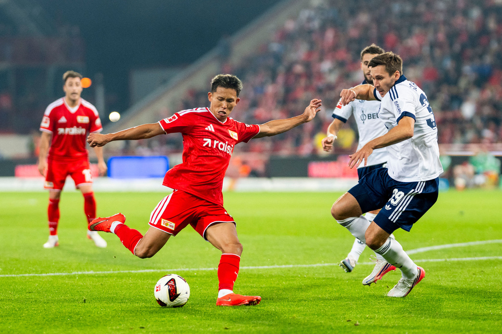 Union's Woo-yeong Jeong, attemps to shoot as Berlin's Max Wöber defends during the German Bundesliga soccer match between Union Berlin and FC Schalke in Berlin, Friday, Sept. 11, 2026. (Julius Frick/dpa via AP)