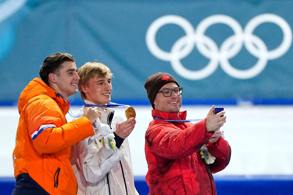 Jordan Stolz of the U.S., center and gold medal, Jenning de Boo of the Netherlands, left and silver medal, and Laurent Dubreuil of Canada, right and bronze medal, celebrate on the podium of the men's 500 meters speedskating race at the 2026 Winter Olympics, in Milan, Italy, Saturday, Feb. 14, 2026. (AP Photo/Ben Curtis)