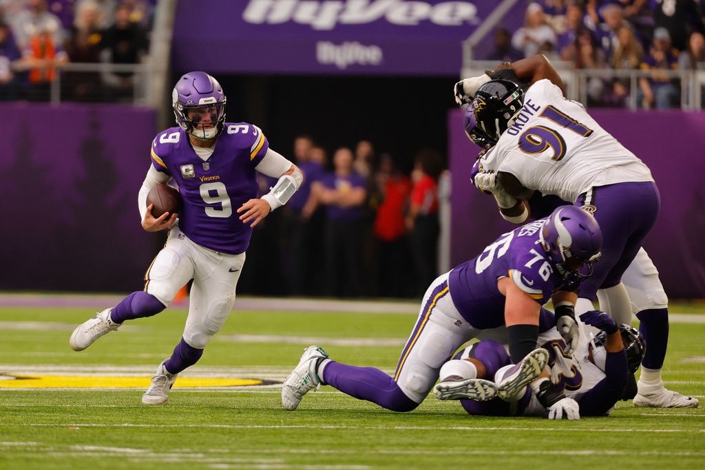Minnesota Vikings quarterback J.J. McCarthy (9) scrambles as guard Will Fries (76) blocks Baltimore Ravens defensive tackle CJ Okoye (91) in the first half of an NFL football game, Sunday, Nov. 9, 2025, in Minneapolis. (AP Photo/Bruce Kluckhohn)