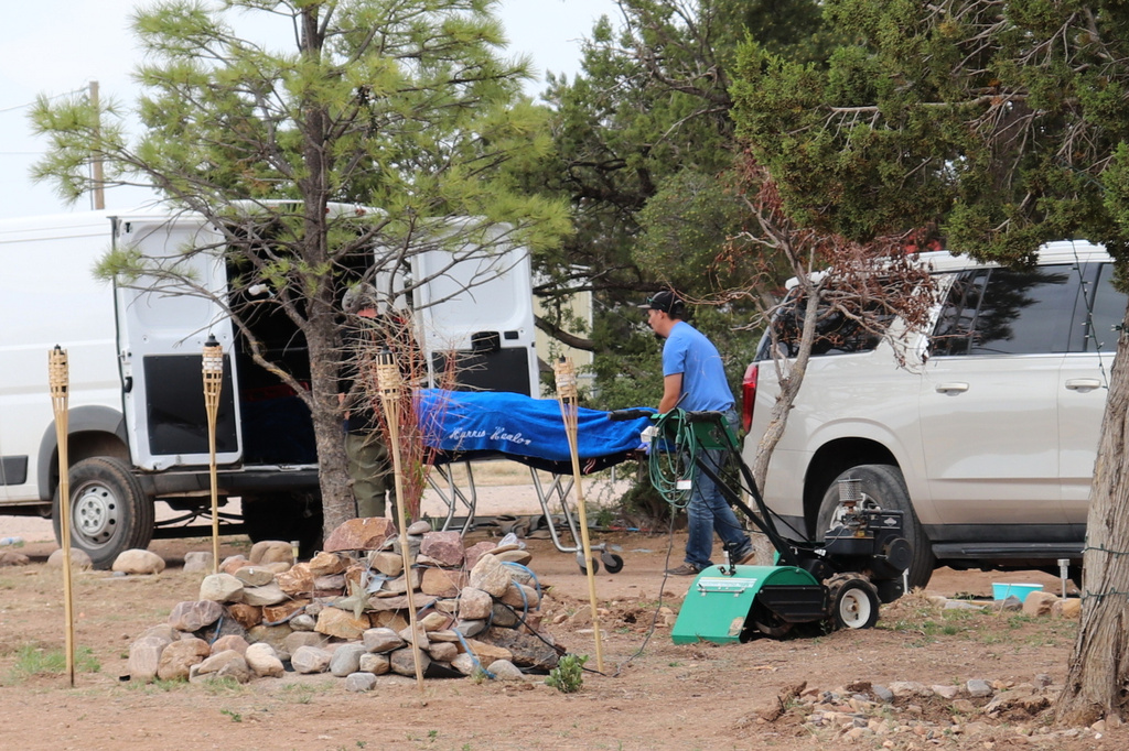 Workers remove a body in Mountainair, N.M., Wednesday, May 20, 2026, after several people died and more than a dozen first responders were exposed to an unknown substance. (AP Photo/Savannah Peters)