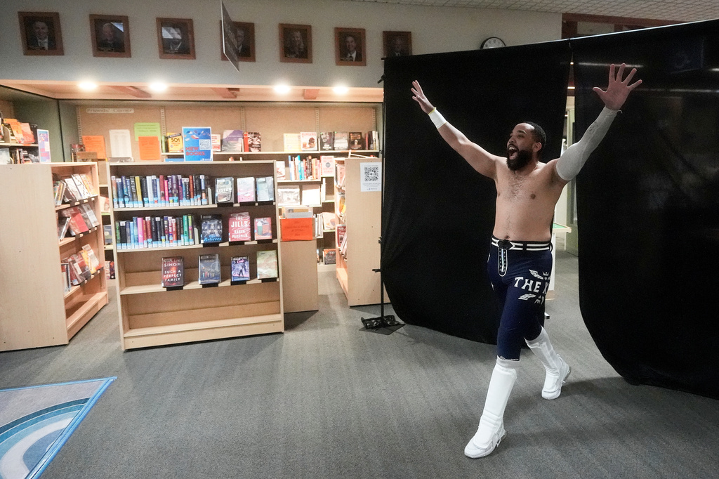 Wrestler TJ Black reacts as he walks past books during a Lucha Libro pro wrestling event at Benicia Public Library Saturday, May 2, 2026, in Benicia, Calif. (AP Photo/Jeff Chiu)