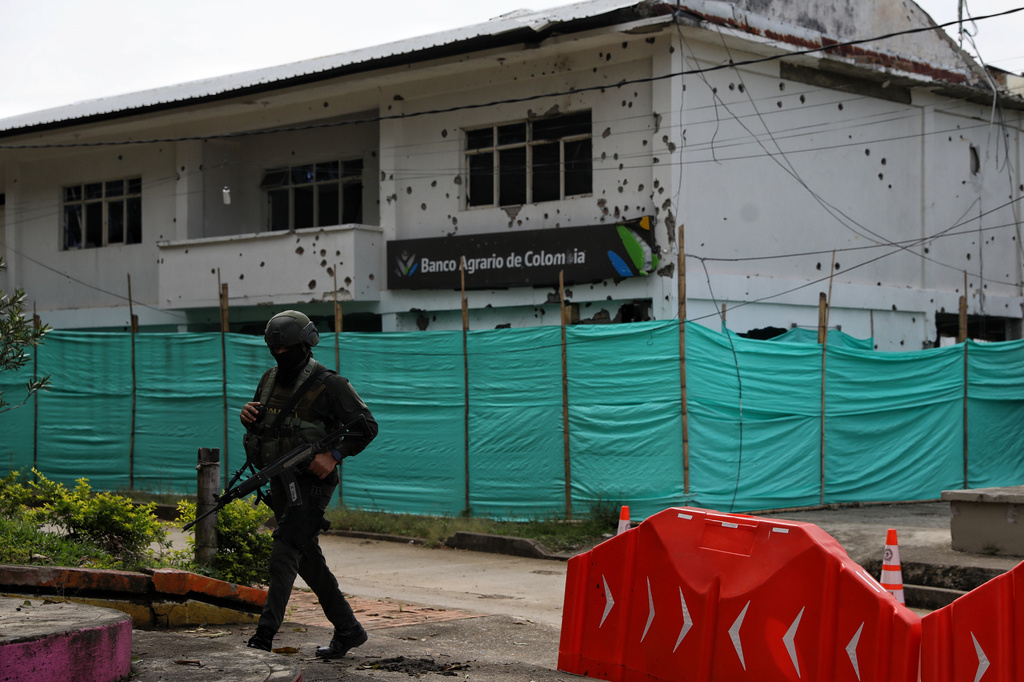 A police officer walks near a branch of the Banco Agrario damaged in an attack by dissidents of the former Revolutionary Armed Forces of Colombia, or FARC, in Buenos Aires, Cauca, ahead of Colombia's presidential election, Wednesday, May 20, 2026. (AP Photo/Santiago Saldarriaga)