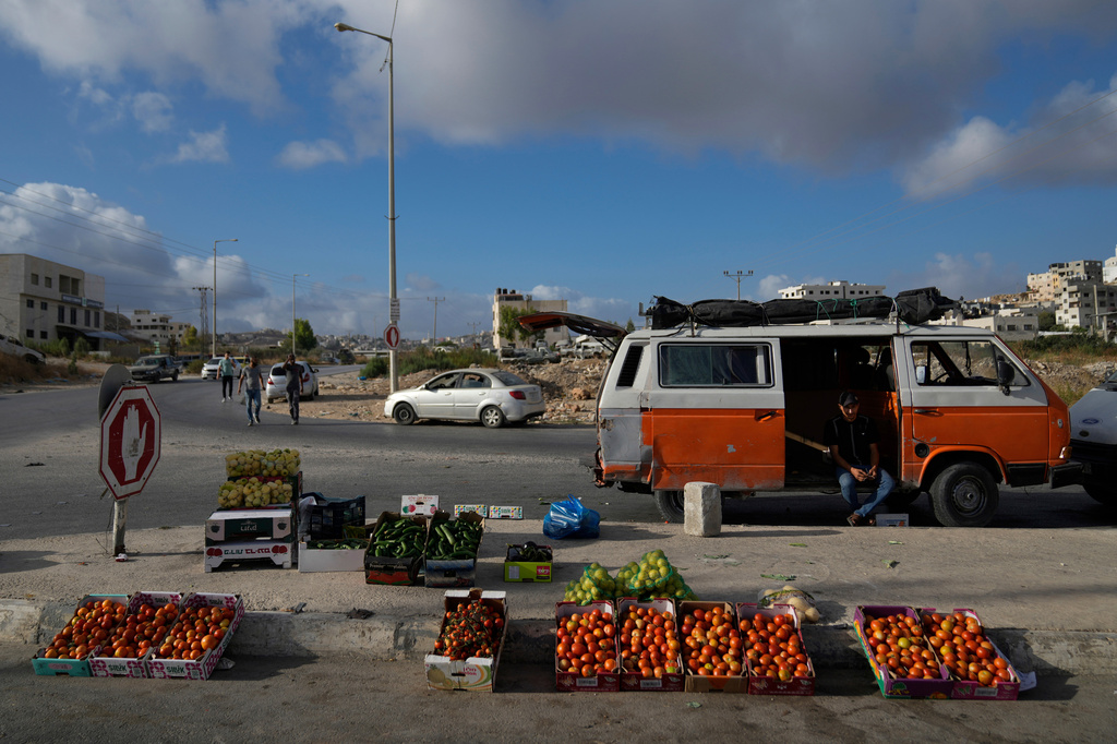 FILE - A Palestinian street vendor waits for customers while he displays vegetables for sale in the weekly market at the eastern outskirts of the West Bank city of Nablus Monday, Sept. 16, 2024. (AP Photo/Nasser Nasser, File)