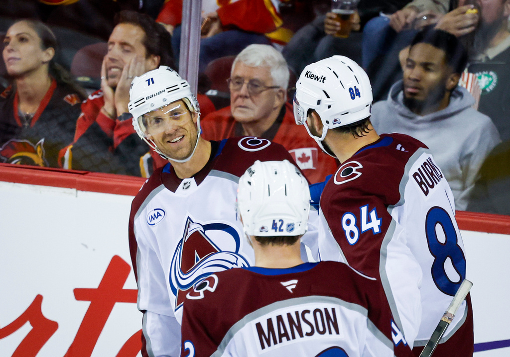 Colorado Avalanche's Jaden Schwartz, left, celebrates after his goal with teammates during the third period of an NHL hockey game against the Calgary Flames in Calgary, Alberta, Thursday, Oct. 8, 2026. (Jeff McIntosh/The Canadian Press via AP)