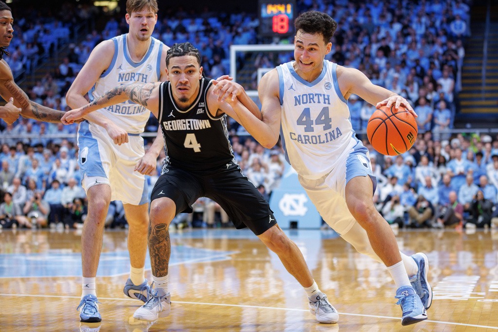 North Carolina's Luka Bogavac (44) drives against Georgetown's Caleb Williams (4) during the first half of an NCAA college basketball game in Chapel Hill, N.C., Sunday, Dec. 7, 2025. (AP Photo/Ben McKeown)