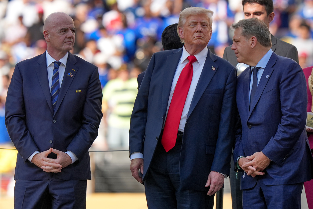FILE - President Donald Trump, center, talks with Chelsea football club owner Todd Boehly, right, as FIFA president Gianni Infantino, left, looks on before the trophy ceremony of the Club World Cup final soccer match in East Rutherford, N.J., Sunday, July 13, 2025. (AP Photo/Frank Franklin II, File)