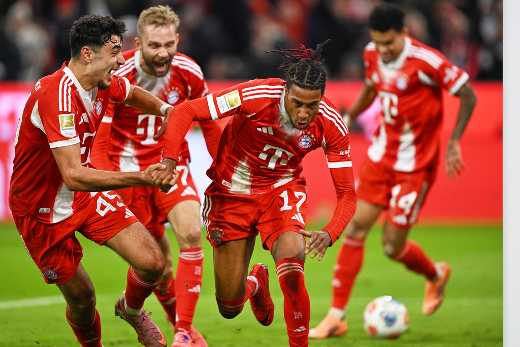 Bayern's Michael Olise, centre, celebrates with teammates after scoring his side's second goal during the Bundesliga soccer match between Bayern Munich and Borussia Dortmund in Munich, Germany, Saturday, Oct. 18, 2025. (AP Photo/Lennart Preiss)