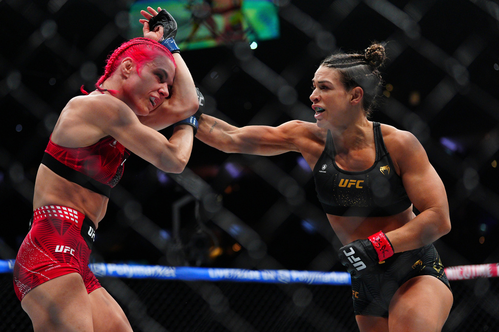 Mackenzie Dern, right, punches Gillian Robertson in a women's strawweight title fight at the UFC 330 mixed martial arts event Saturday, Aug. 15, 2026, in Philadelphia. (AP Photo/Derik Hamilton)