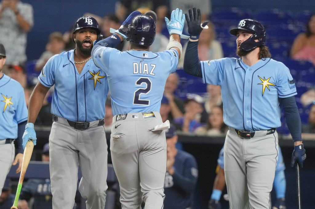 Tampa Bay Rays' Junior Caminero, left, and Yandy Díaz (2) celebrate after scoring on a triple by Richie Palacios during the first inning of a baseball game against the Miami Marlins Friday, June 5, 2026, in Miami. (AP Photo/Marta Lavandier)