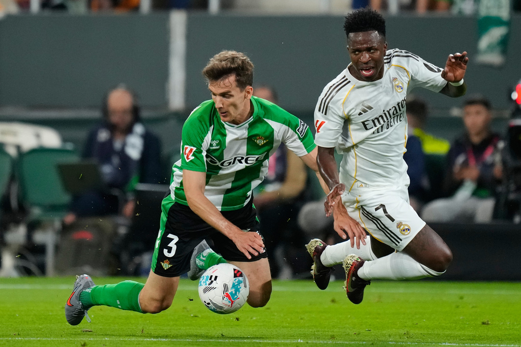 Betis' Diego Llorente , left, and Real Madrid's Vinicius Junior fight for the ball during a La Liga soccer match between Real Betis and Real Madrid in Seville, Spain, Friday, April 24, 2026. (AP Photo/Jose Breton)