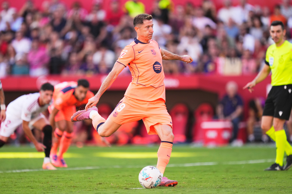 Barcelona's Robert Lewandowski shoots a penalty kick during the Spanish La Liga soccer match between Sevilla and Barcelona at the Ramon Sanchez Pizjuan stadium in Seville, Spain, Sunday, Oct. 5, 2025. (AP Photo/Jose Breton)