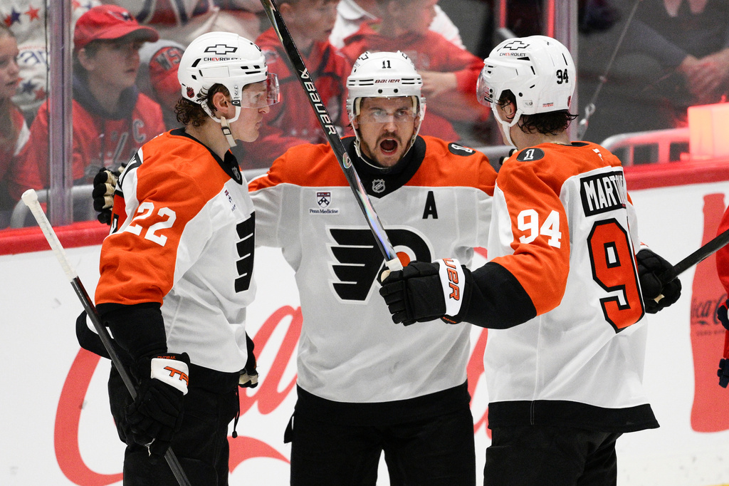 Philadelphia Flyers center Christian Dvorak (22) celebrates his goal with right wing Travis Konecny (11) and right wing Porter Martone (94) during the third period of an NHL hockey game against the Washington Capitals, Tuesday, March 31, 2026, in Washington. (AP Photo/Nick Wass)