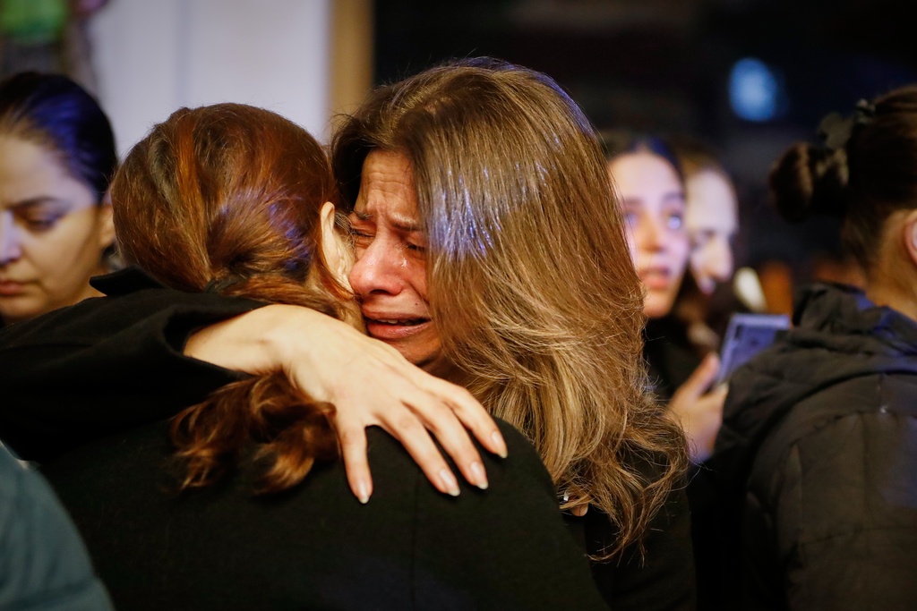 Two women hug each other as they attend the lighting of a Christmas tree at the Greek Orthodox Mar Elias Church, months after the church was the site of a deadly suicide bombing, in the Dweila neighborhood of Damascus, Syria, Tuesday, Dec. 23, 2025.(AP Photo/Omar Sanadiki)