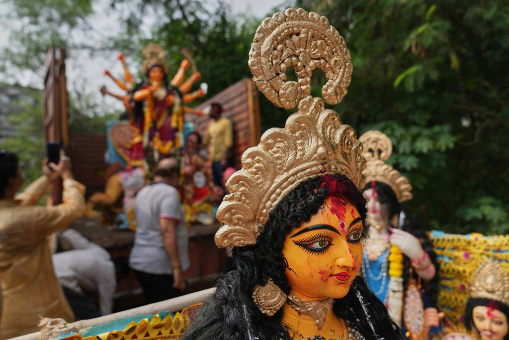 Devotees prepare to immerse an idol of Hindu goddess Durga in a makeshift water pit at the end of Durga Puja festival in New Delhi, India, Thursday, Oct. 2, 2025. (AP Photo/Manish Swarup)