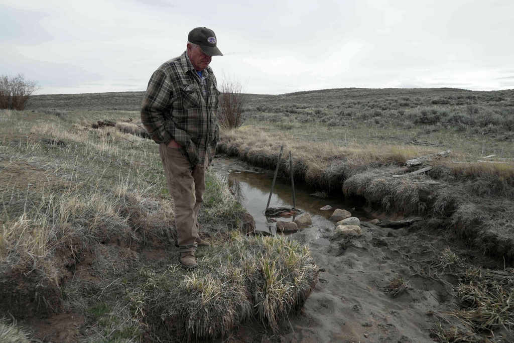 Philip Anderson looks at a dry ditch that usually transports water for stock and irrigation, Tuesday, March 31, 2026, in Walden, Colo. (AP Photo/Brittany Peterson)