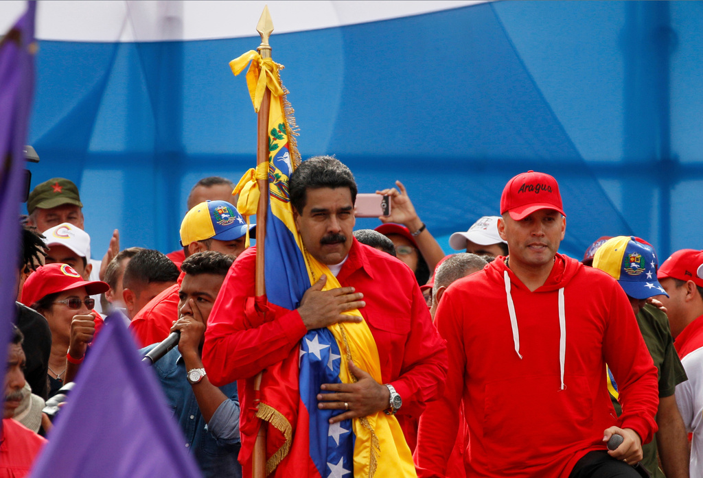 FILE - Venezuela's President Nicolas Maduro embraces a national flag during a rally in Caracas, Venezuela, July 27, 2017. Maduro provoked international outcry and enraged an opposition demanding his resignation with his push to elect an assembly that will rewrite the nation's constitution. (AP Photo/Ariana Cubillos, File)