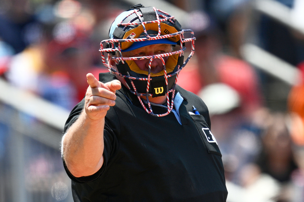 FILE - Home plate umpire Bill Miller calls a strike as he wears a patriotic themed mask during the ninth inning of a baseball game between the Washington Nationals and the Boston Red Sox, July 4, 2025, in Washington. (AP Photo/Nick Wass, File)
