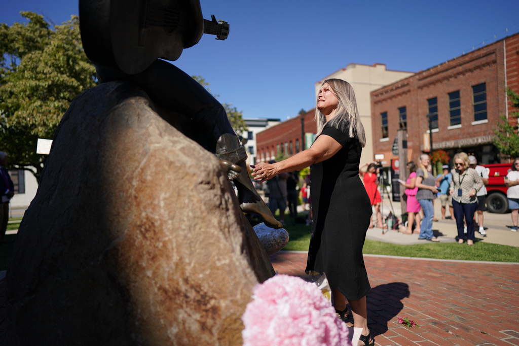 A woman stands before a statue of Dolly Parton in Sevierville, Tenn., Tuesday, Aug. 25, 2026. (AP Photo/Camden Hall)