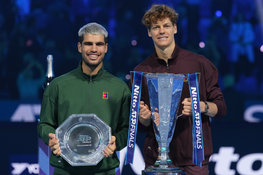 Spain's Carlos Alcaraz, left, and winner Italy's Jannik Sinner stand on the podium after the final tennis match of the ATP World Tour Finals, in Turin, Italy, Sunday, Nov. 16, 2025. (AP Photo/Antonio Calanni)