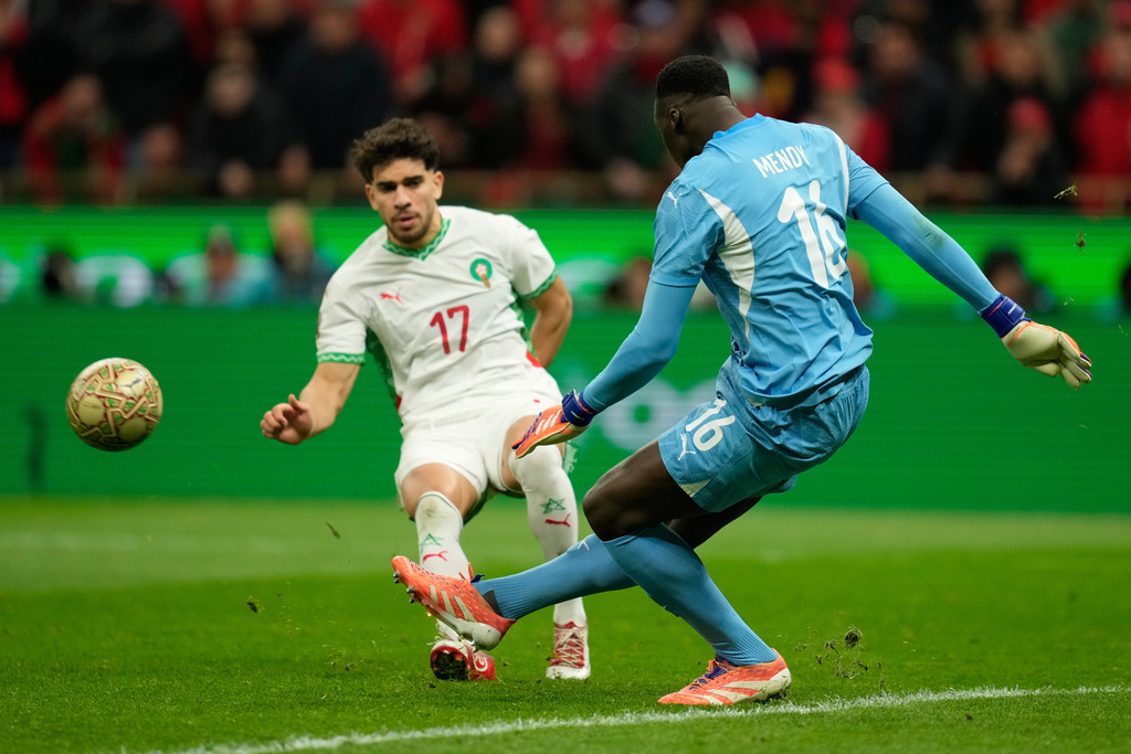 Senegal's goalkeeper Edouard Osoque Mendy clears the ball in front of Morocco's Abdessamad Ezzalzouli during the Africa Cup of Nations final soccer match between Senegal and Morocco, in Rabat, Morocco, Sunday, Jan. 18, 2026. (AP Photo/Mosa'ab Elshamy)