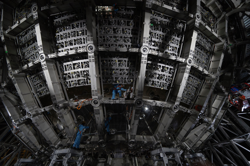 FILE - Workers labor on the underside of the cosmic detector housed underground at the Jiangmen Underground Neutrino Observatory in Kaiping in southern China's Guangdong province, Oct. 11, 2024. (AP Photo/Ng Han Guan, File)