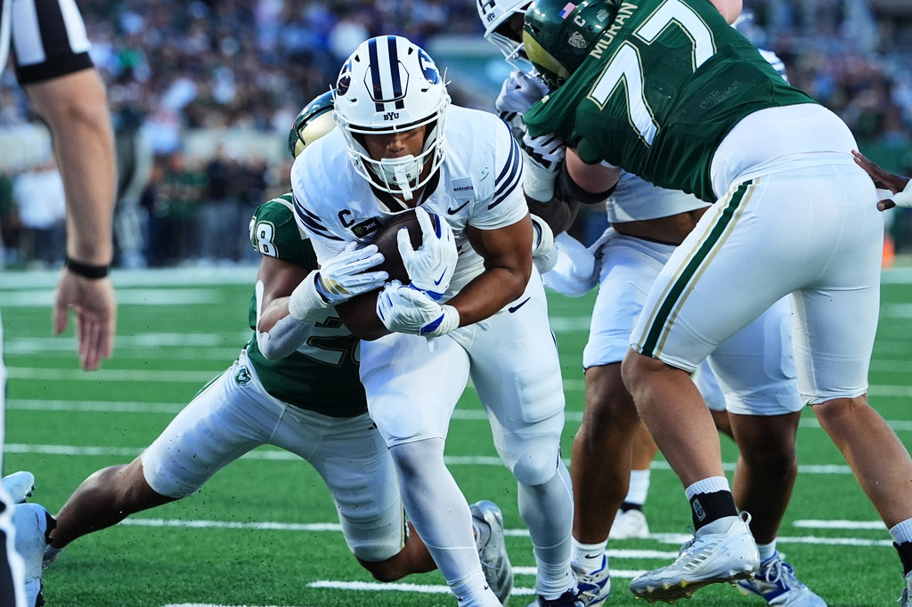 BYU running back Lj Martin, front, drives past Colorado State linebacker Marc Pretto for a touchdown in the first half of an NCAA college football game Saturday, Sept. 19, 2026, in Fort Collins, Colo. (AP Photo/David Zalubowski)