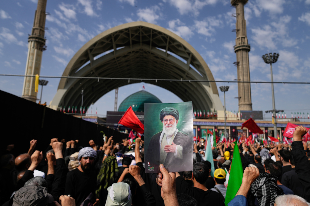 A mourner holds a portrait of the late Iranian Supreme Leader Ayatollah Ali Khamenei as mourners gather for the start of the dayslong funeral ceremonies for Khamenei and members of his family at the Imam Khomeini Mosalla Grand Mosque in Tehran, Iran, Saturday, July 4, 2026. (AP Photo/Altaf Qadri)