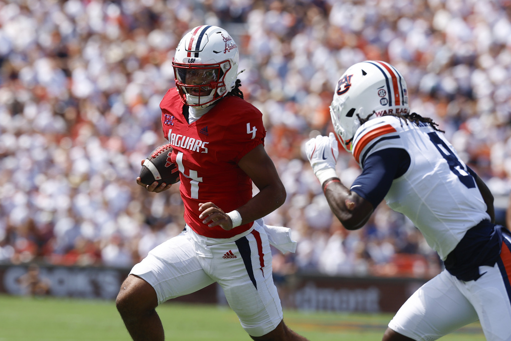 South Alabama quarterback Bishop Davenport (4) carries the ball as he tries to get around Auburn safety Kaleb Harris (8) during the first half of an NCAA college football game, Saturday, Sept. 13, 2025, in Auburn, Ala. (AP Photo/Butch Dill)
